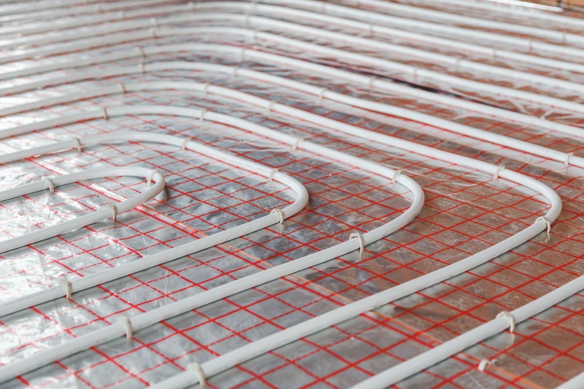 Underfloor heating pipes laid over insulation on a floor