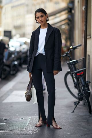 woman wearing white T-shirt, blazer, jeans, and sandals