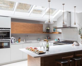 An example U-shaped kitchen ideas in a pale scheme with skylights and a breakfast bar.