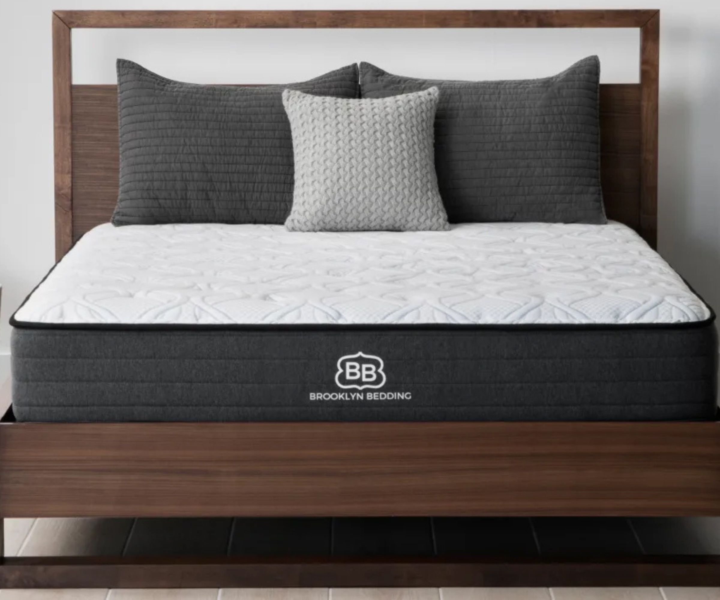 Gray pillows on a Brooklyn Bedding mattress on a bed frame.