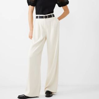 Flat lay image of a woman wearing tailored trousers and black shoes