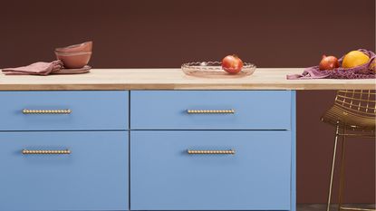 Plank Hardware cabinet handles on a blue slab kitchen.