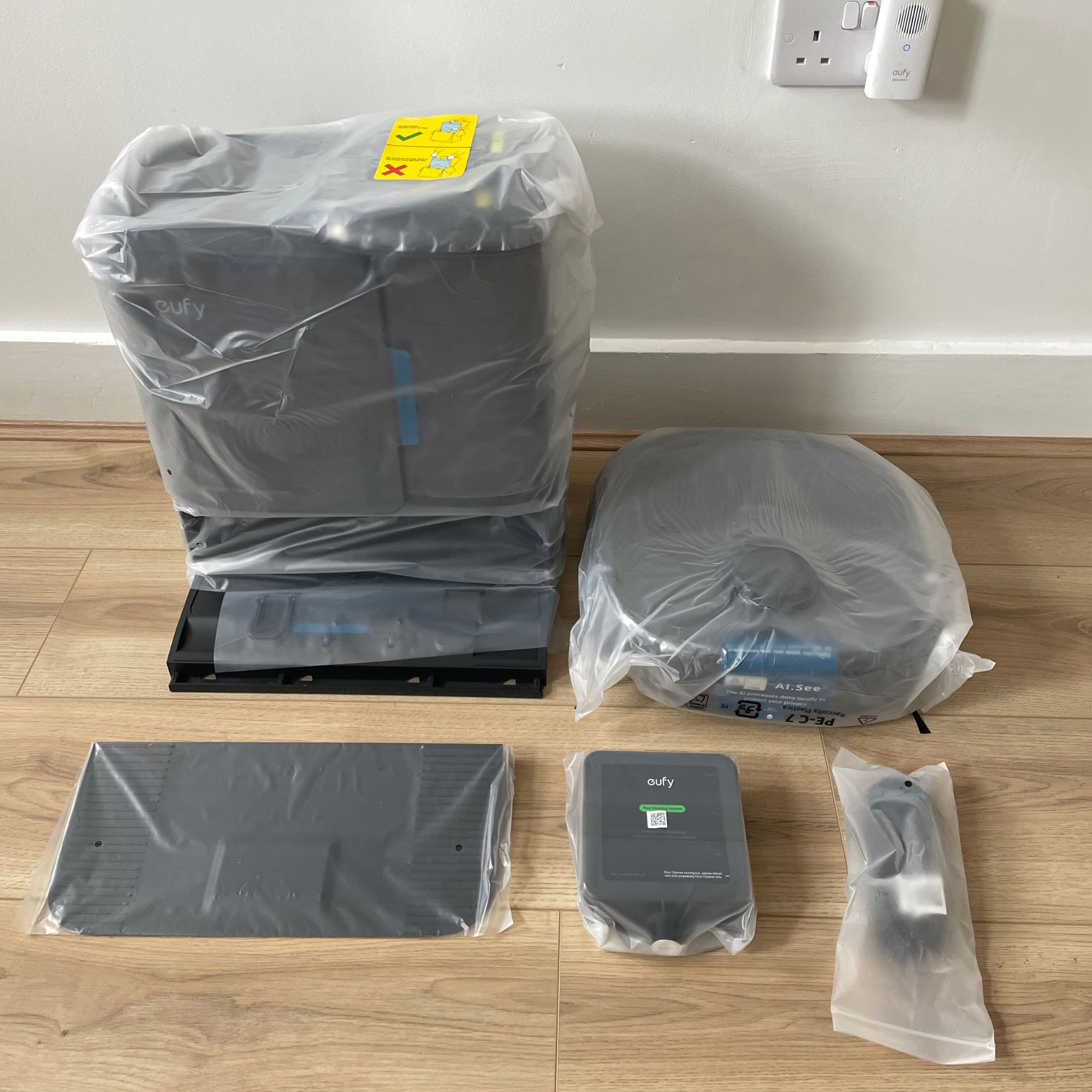 Eufy Robot Vacuum Omni E25 components wrapped in plastic and laid out on the floor