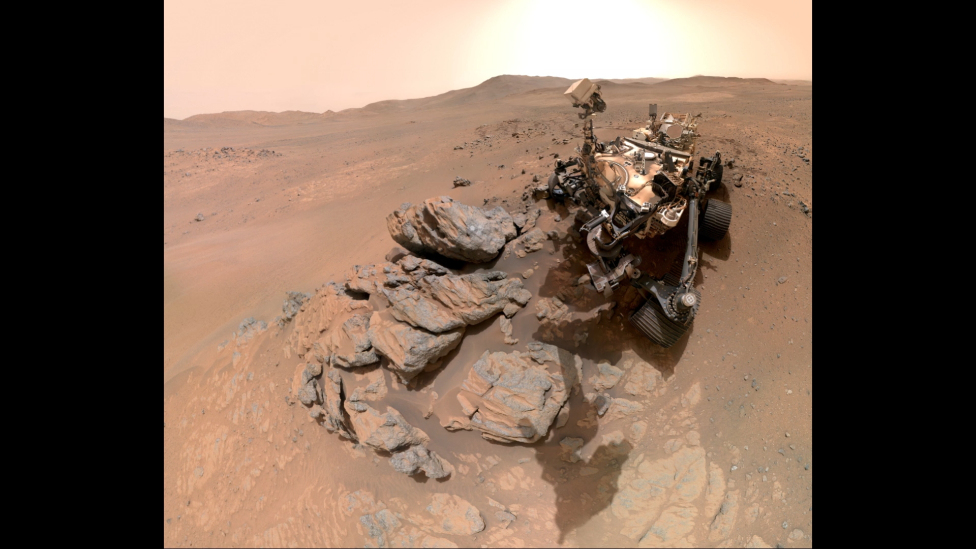 A metal-looking rover with four wheels in an arid, red-brown landscape blah blahblahblahblahblahblahblahblahblahblahblahblahblahblahblahblahblahblahblahblahblahblahblahblahblahblahblahblahblahblahblahblahblahblahblahblahblahblah