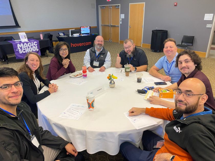 Eight attendees working at a round table 