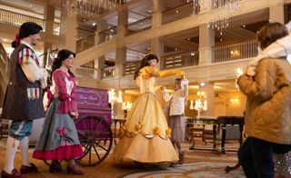 People dressed as Disney characters inside hotel with guests