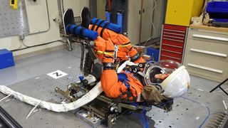 The 'moonikin' test dummy undergoes a vibrational test in a chair from the new Orion module at the Kennedy Space Center.