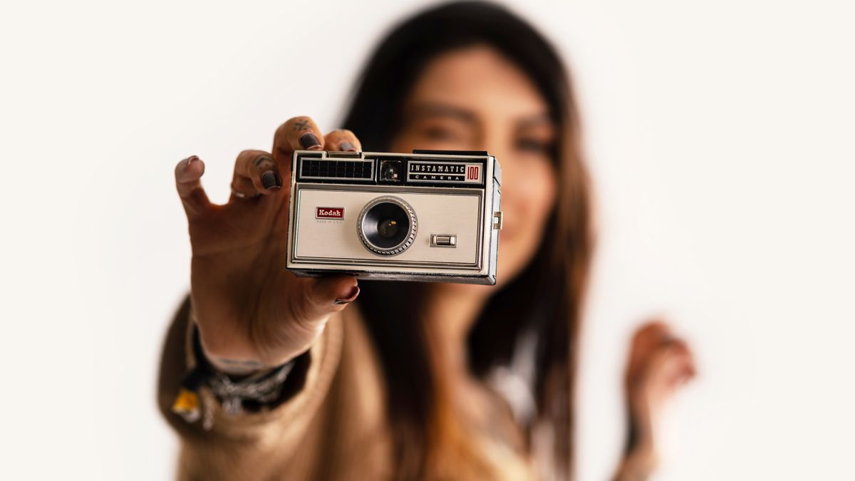 woman holding camera up to screen 