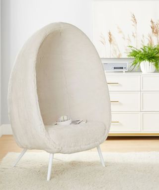 A faux fur cream egg-shaped chair