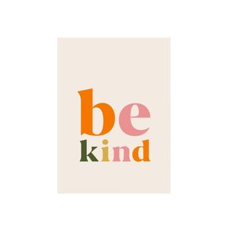A wall artwork that says 'be kind' in multi-colored font