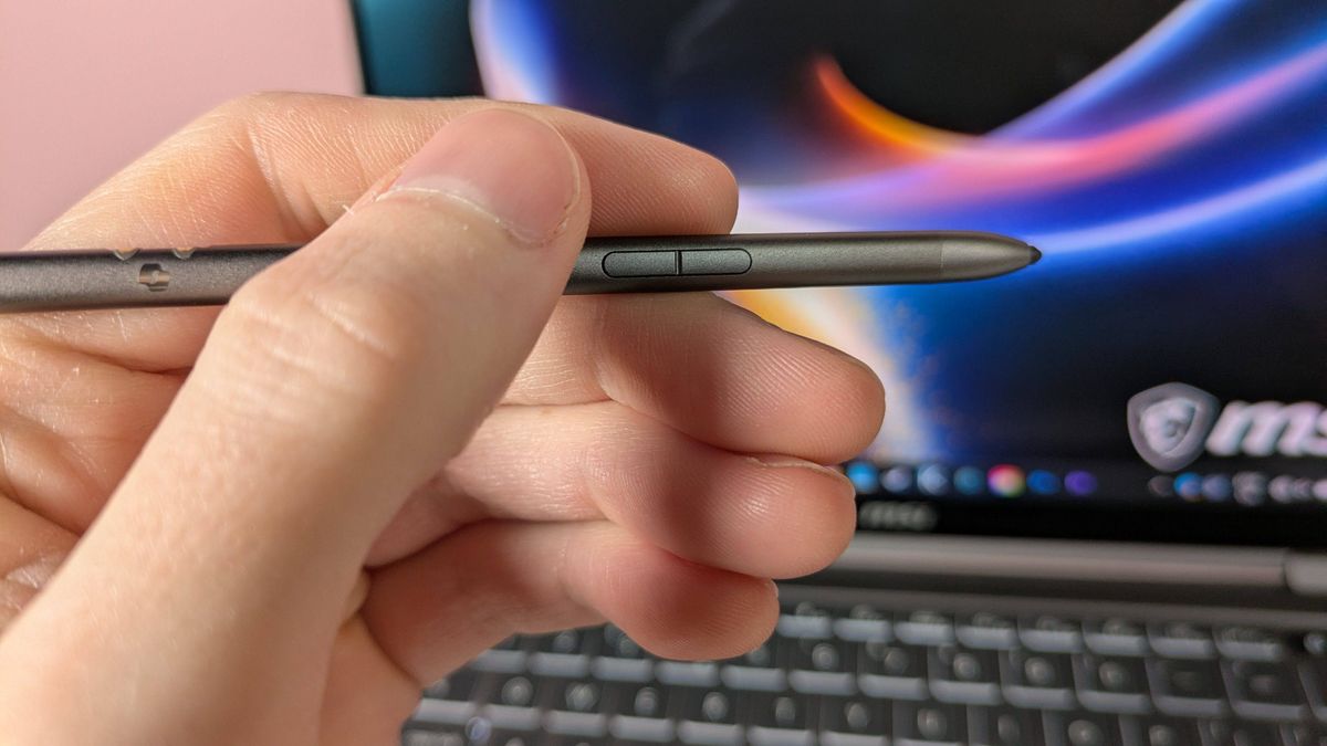 Hand holding MSI Nano Pen with MSI Prestige 14 Flip AI+ and pink wall in background