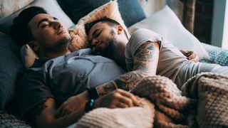 Two men asleep in bed