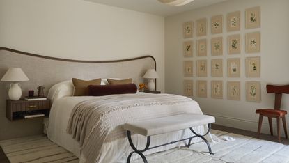 A neutral bedroom with beige walls, a large headboard with brown trim, and a gallery wall of botanics on the wall