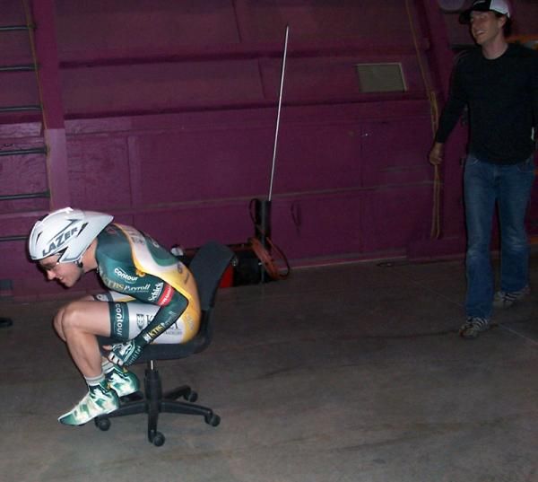 With a push from Scott Zwizanski, Ryan Anderson puts his aero position to the test on an office chair.