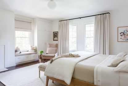 A bedroom with seating by the window