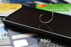 Phishing phone call scams vishing - concept. Cellphone with fishing hook, credit cards, gift cards