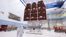 A pair of scientists stand in front of the fully completed Roman space telescope