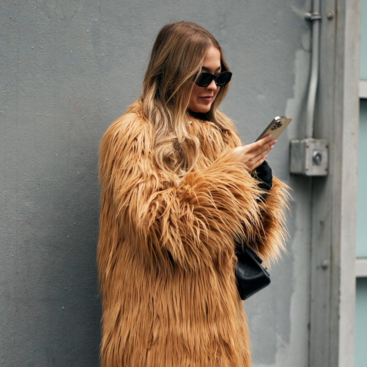 woman wearing a fur coat with glasses. 