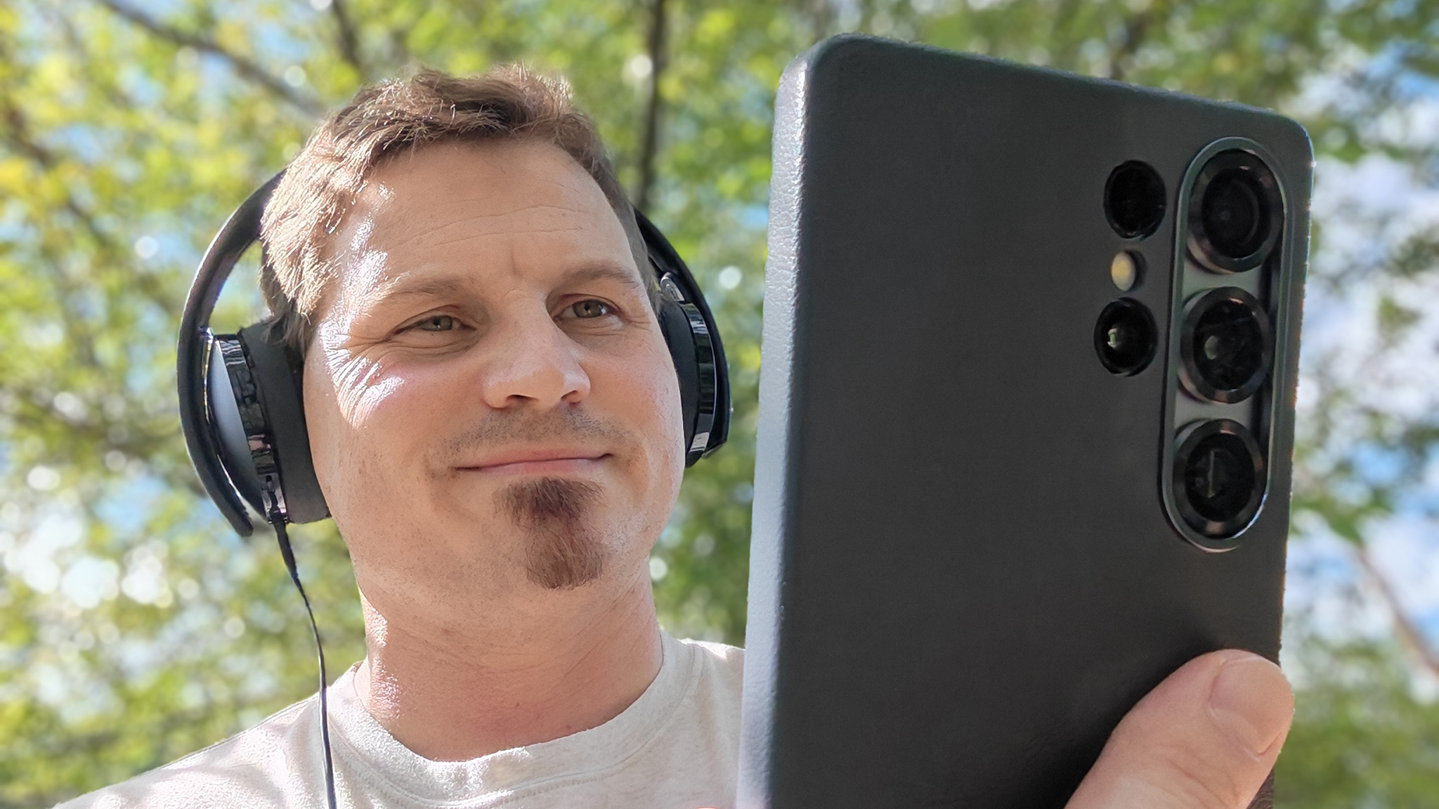 Holding a Samsung Galaxy S25 Ultra while wearing a pair of wired Sony headphones