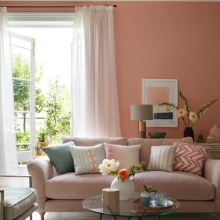 A peach-coloured living room with light voile curtains