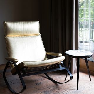golden relaxing chair with wooden floor below