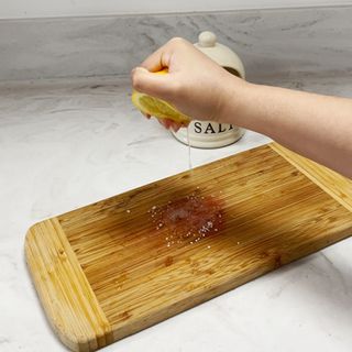 Cleaning wooden chopping board with salt and lemon