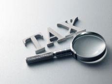 the word tax next to magnifying glass