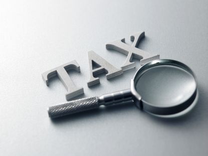 the word tax next to magnifying glass