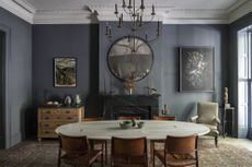 Dark grey dining room with statement oval table.