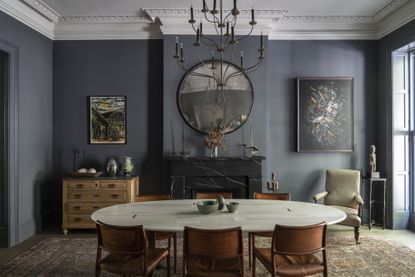 Dark grey dining room with statement oval table.