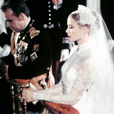 Grace Kelly wearing wedding dress and veil at alter with Prince of Monaco 