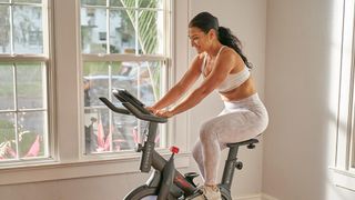 Peloton vs Echelon: image of woman riding Echelon bike at home