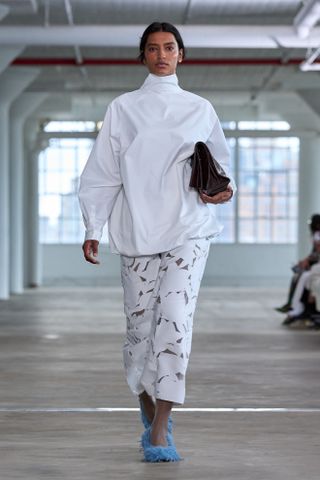 A model walks the Tibi runway wearing the high-neckline trend.