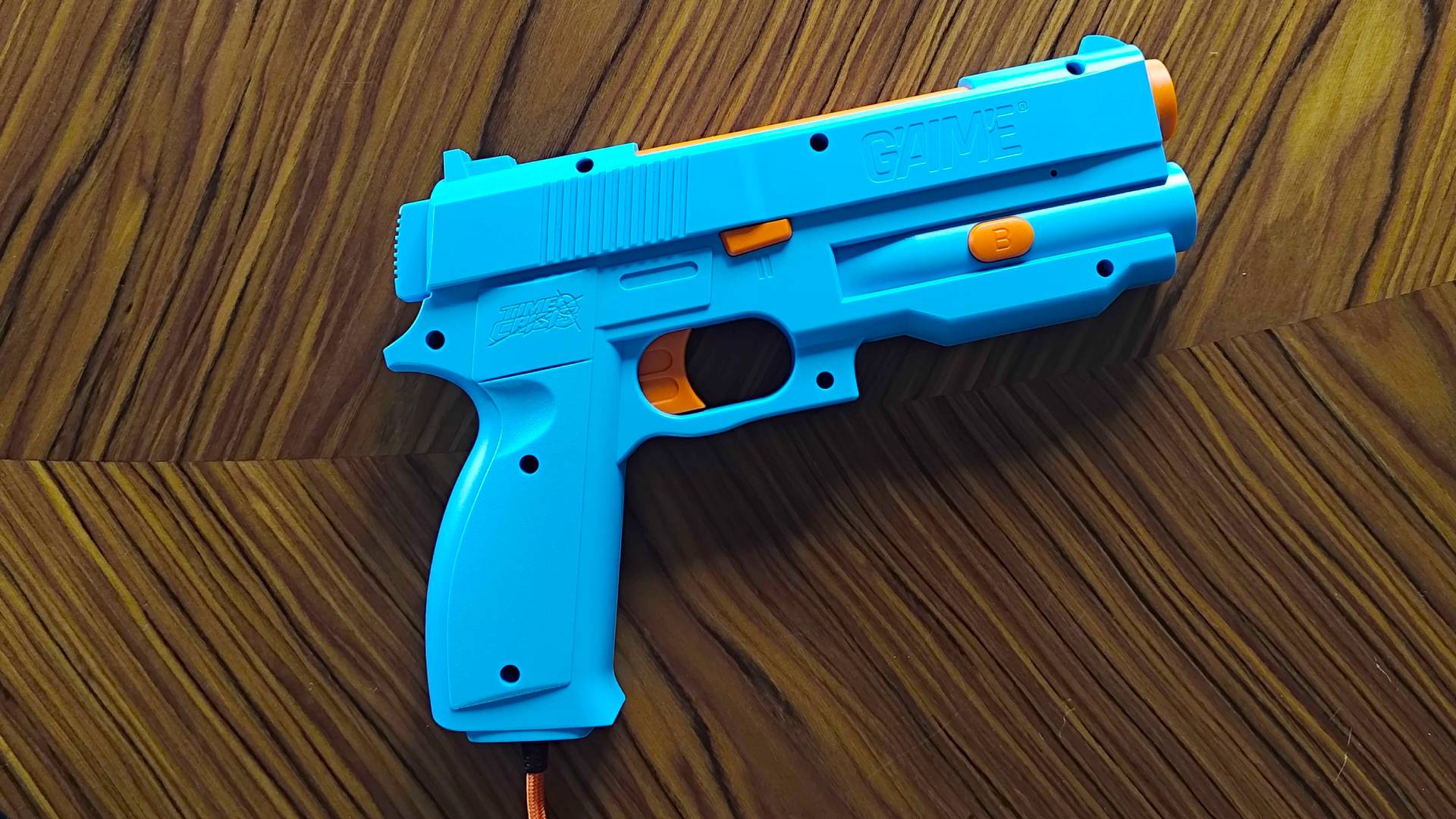 G&#039;AIM&#039;E Time Crisis Lightgun on woodgrain table.