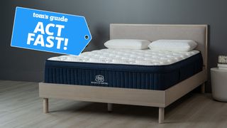 Image shows the Brooklyn Bedding Aurora Luxe cooling mttress on a wooden bedframe with a blue sales badge overlaid