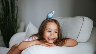 Girl with pet bird on her head