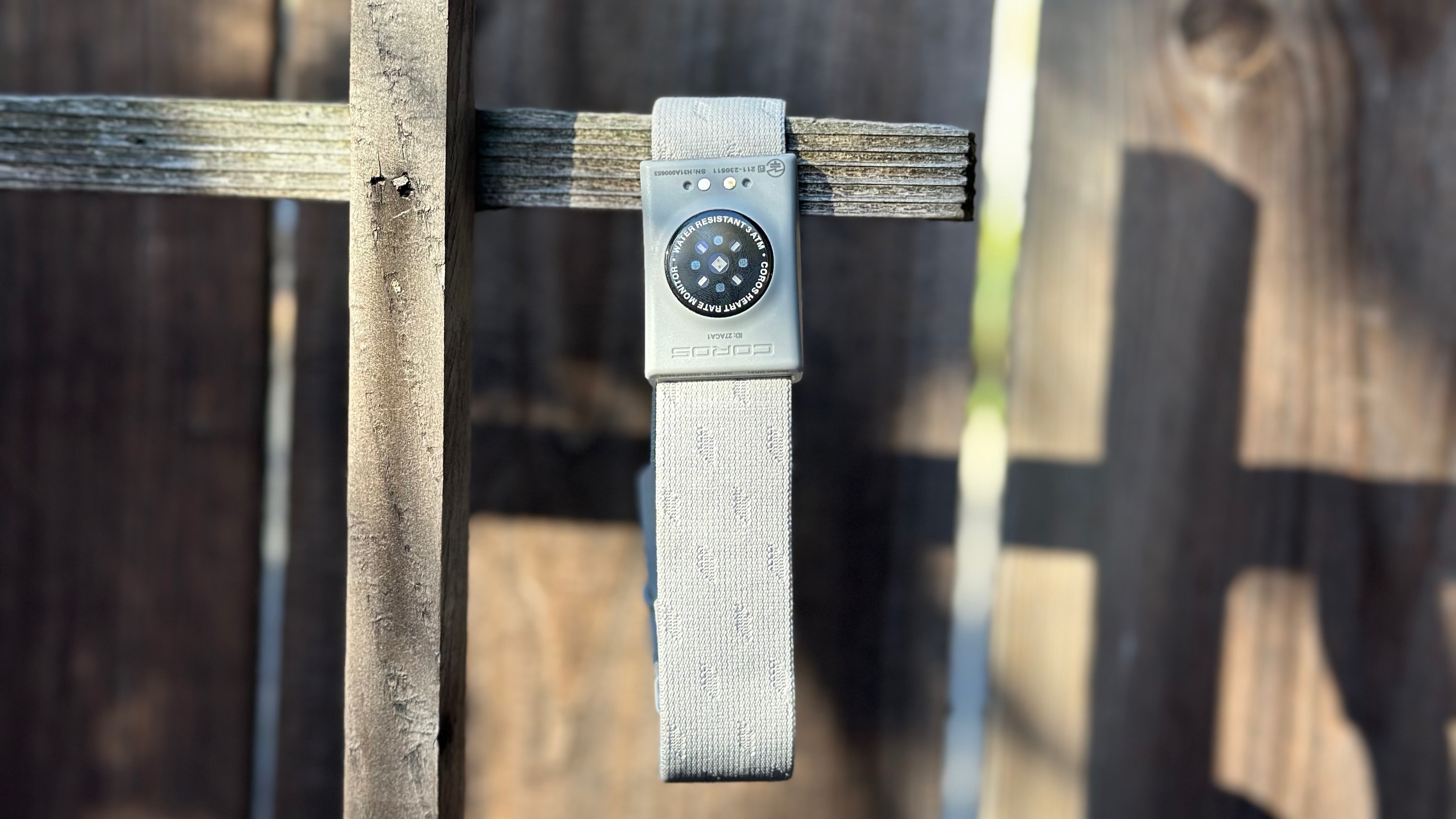 The COROS Heart Rate Monitor hanging off of a fence.