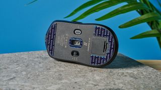 A black Lemokey G1 wireless gaming mouse sitting on a marble slab