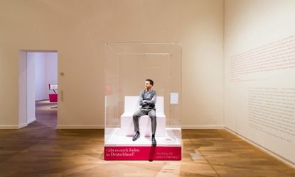 A Jewish man sits in a plexiglas box for the exhibit "The Whole Truth."