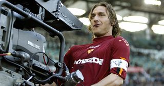 AS Roma's captain Francesco Totti celebrates with a tv camera after scoring against Lazio during their Serie A soccer match at Rome's Olympic stadium 21 April 2004.