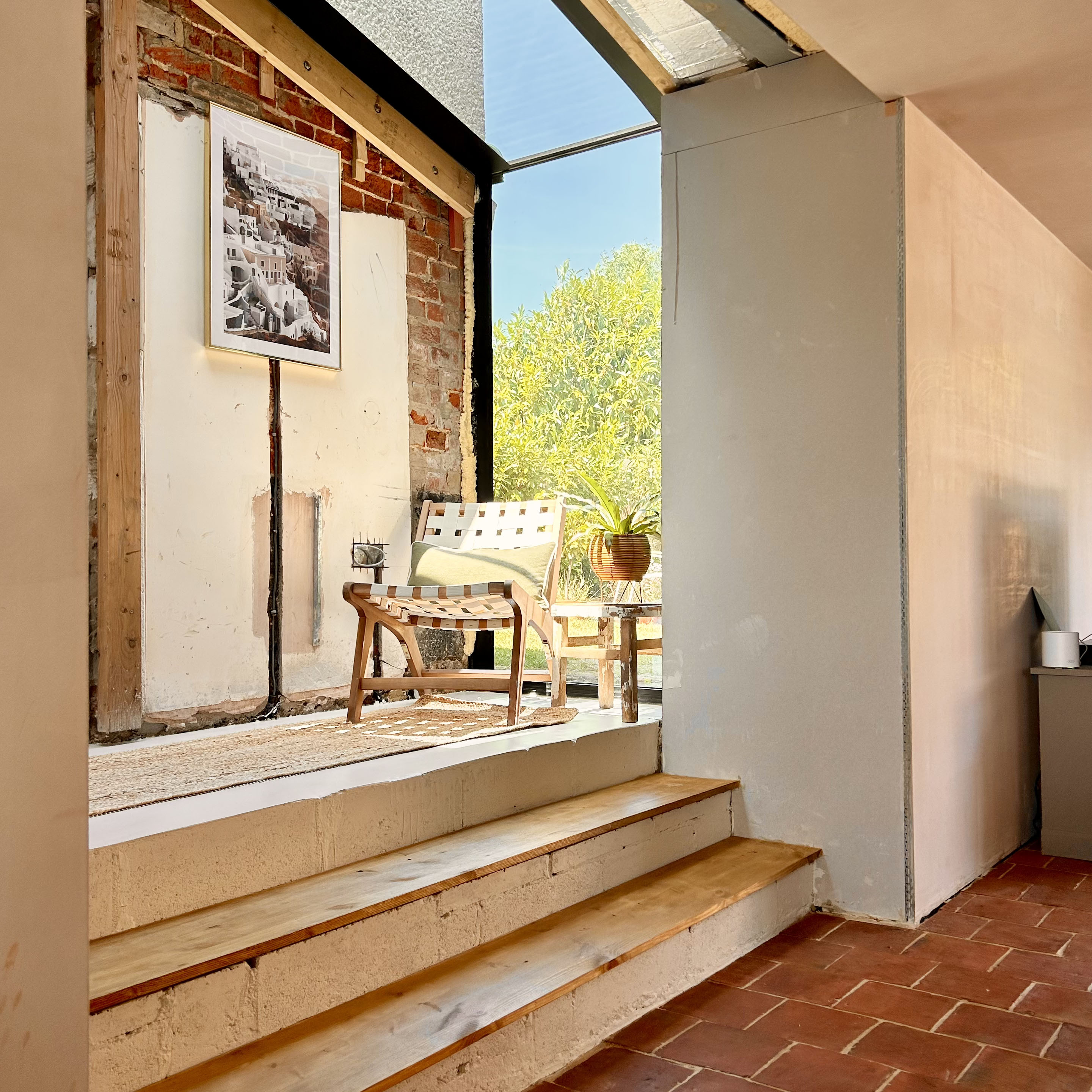 an extension mid-renovation with a chair and houseplant in it