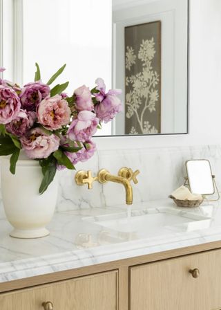 Close up of counter top edge detailing on a marble counter with gold taps