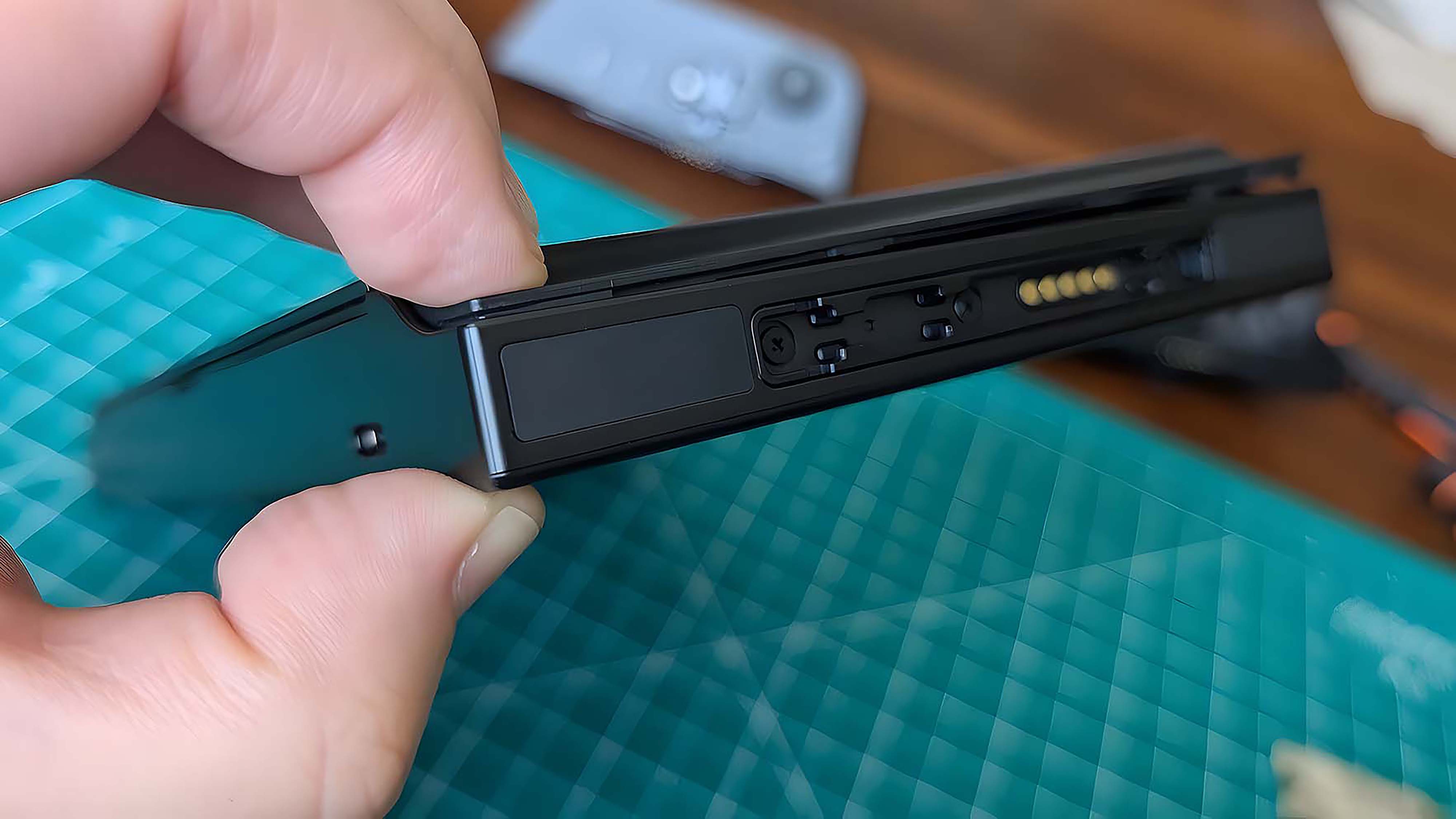A finger and thumb pinching the Lenovo Legion Go case closed.