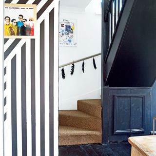 Geo black and white stripes on a hallway wall with grey stairs