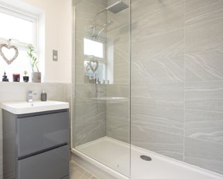 Clean bathroom with gleaming glass shower screen in front of shower
