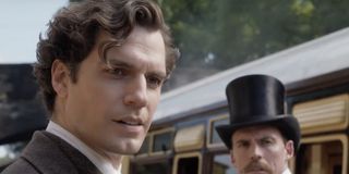 Sherlock (Henry Cavill) and Mycroft (Sam Claflin) stand outside of a train in Enola Holmes