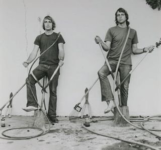 Black and white picture of two men standing with tools