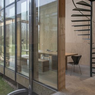 House with glass walls and grey chairs