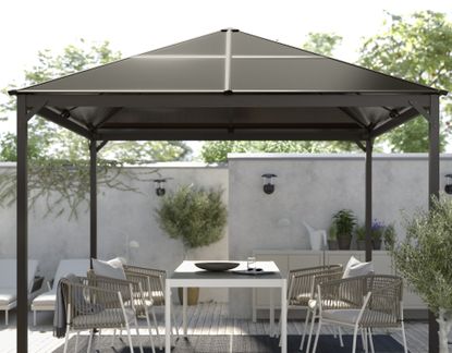 A backyard with a gazebo and a outdoor dining set
