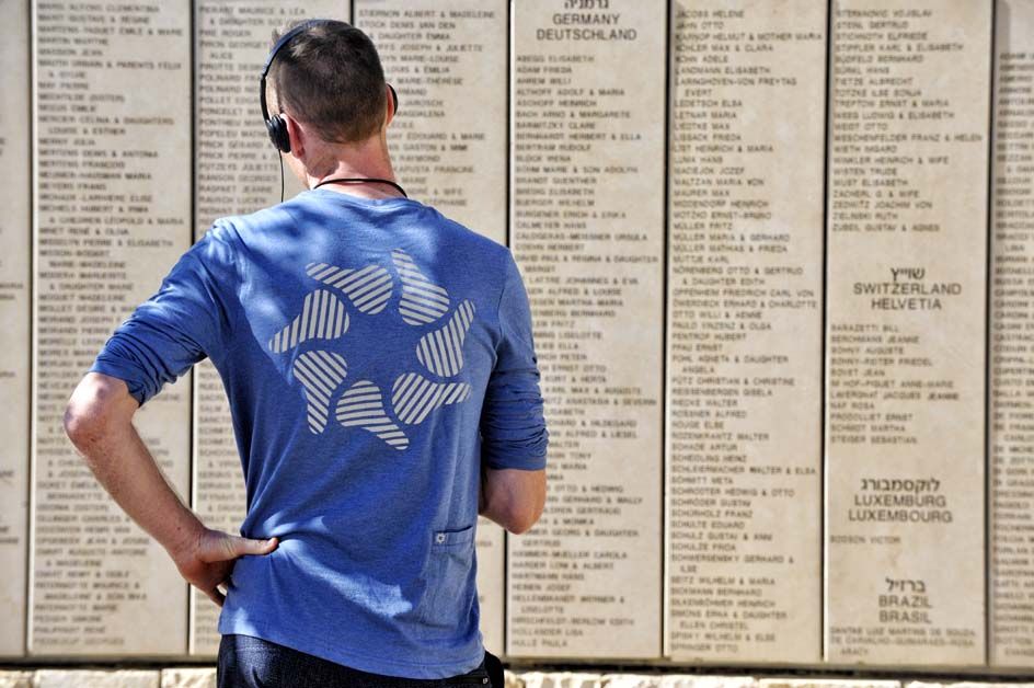 Zak Dempster looks at the names of the Righteous among the nations while listening to the tour guide